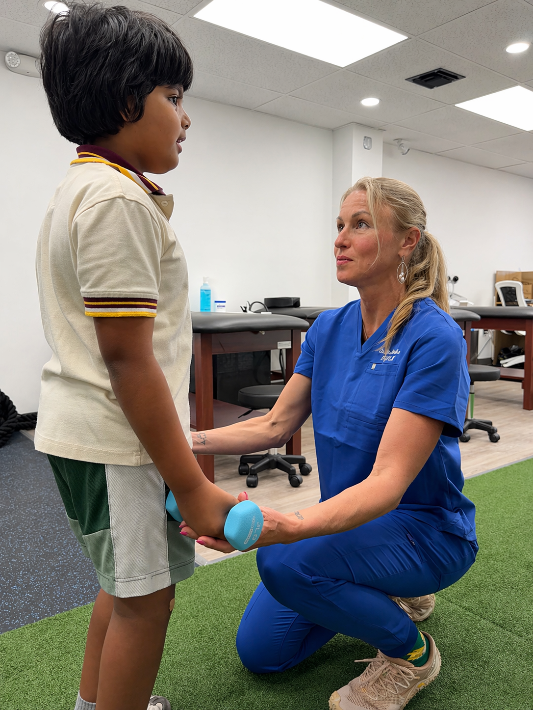 Dr. Alina helping a young patient with rehabilitation exercises